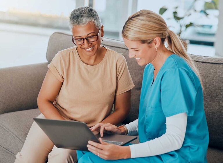 Older adult and family member reviewing care options with a nurse in a bright residential room.
